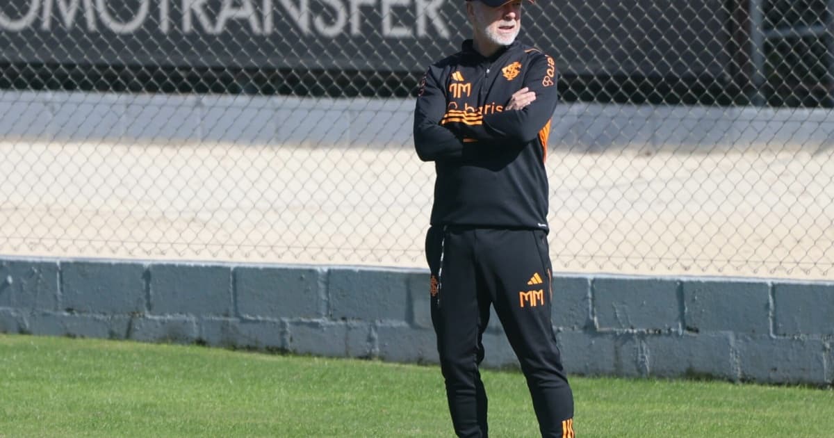 Mano Menezes parado com os braços cruzados e uma bola nos pés durante treino do Inter 