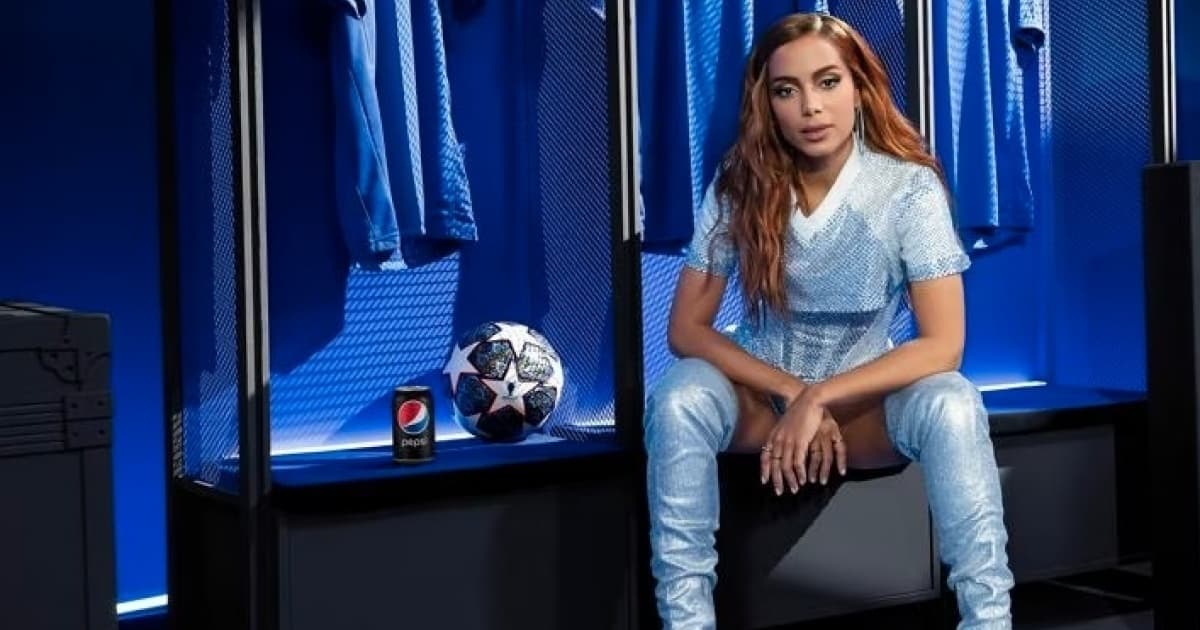 Anitta sentada no vestiário ao lado da bola da final da Champions League