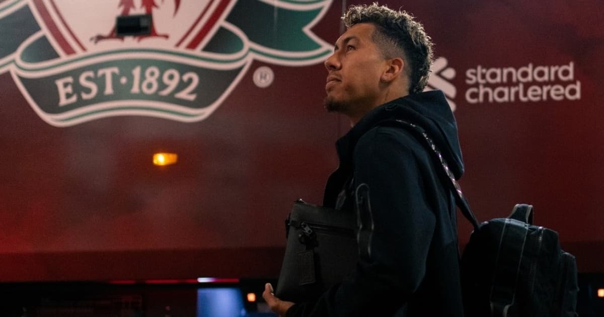 Roberto Firmino caminha ao lado do ônibus do Liverpool