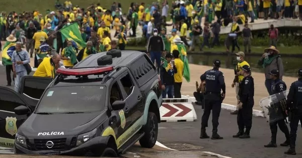 Polícia do DF olhando e carro destruído no dia 8 de janeiro