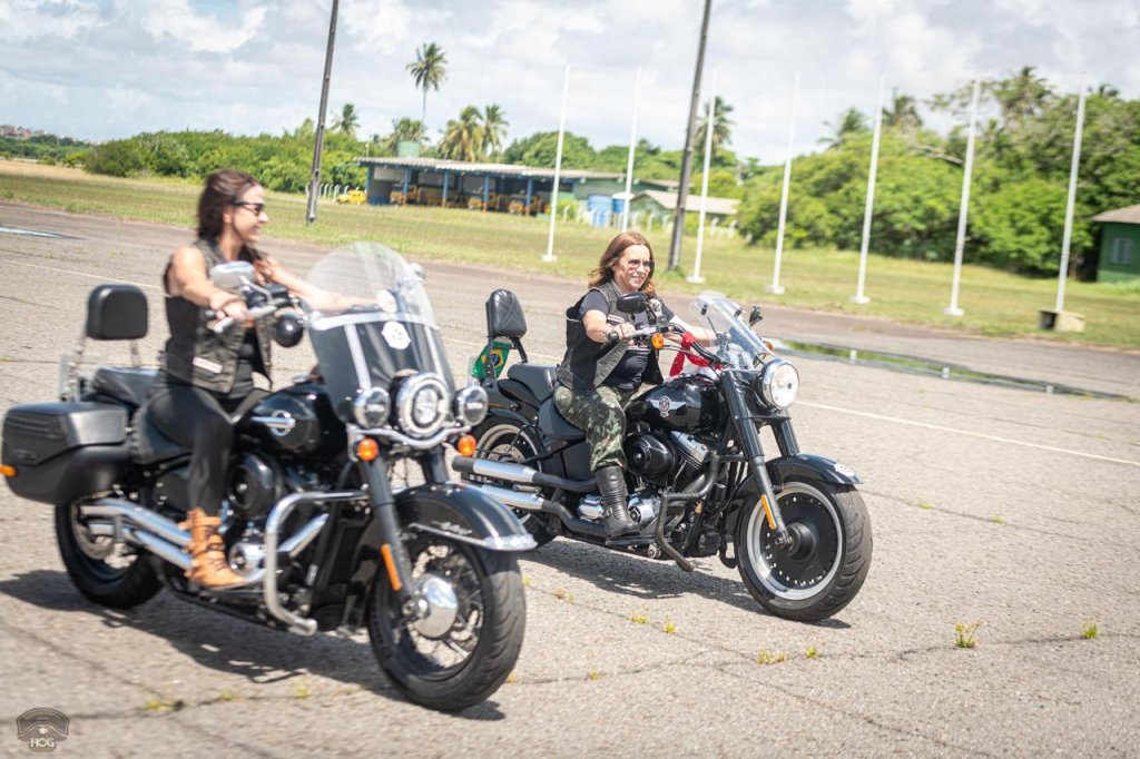 Duas mulheres com suas motos da Harley Davidson